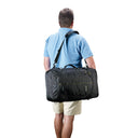Man carrying a black duffel bag on a white background
